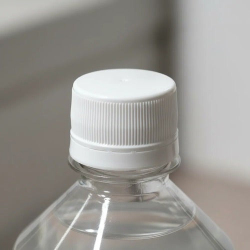 Tapa blanca de rosca en botella transparente de Trini Vital Store para higienizante de frutas y verduras